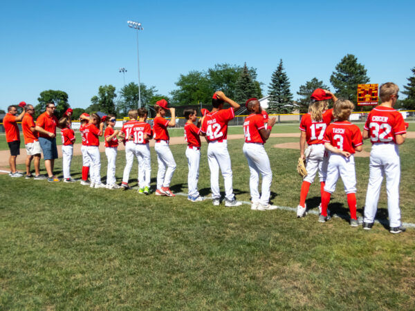 Youth baseball team lined up on field.