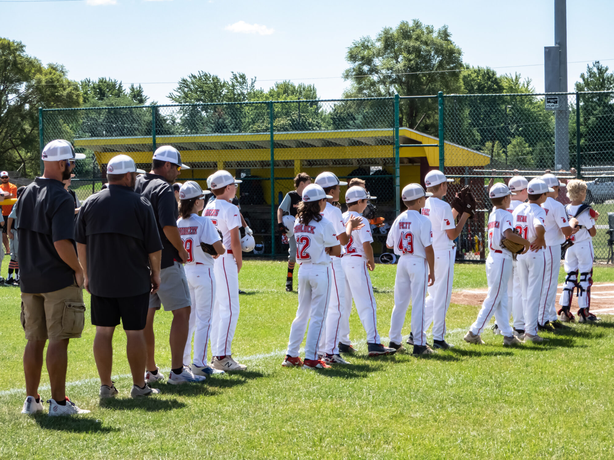 Youth baseball team standing on the field together.