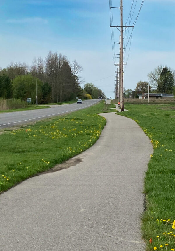 Quiet road beside path with power lines